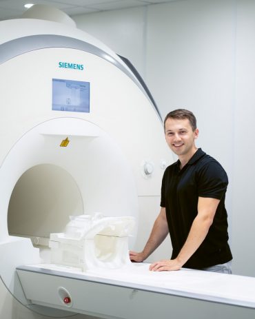 Für eine MRT-Untersuchung bereitet der Physiker Felix Glang eine Kopfspule vor. Neuartige elektronische Komponenten sollen zukünftig schnellere Aufnahmen ermöglichen
